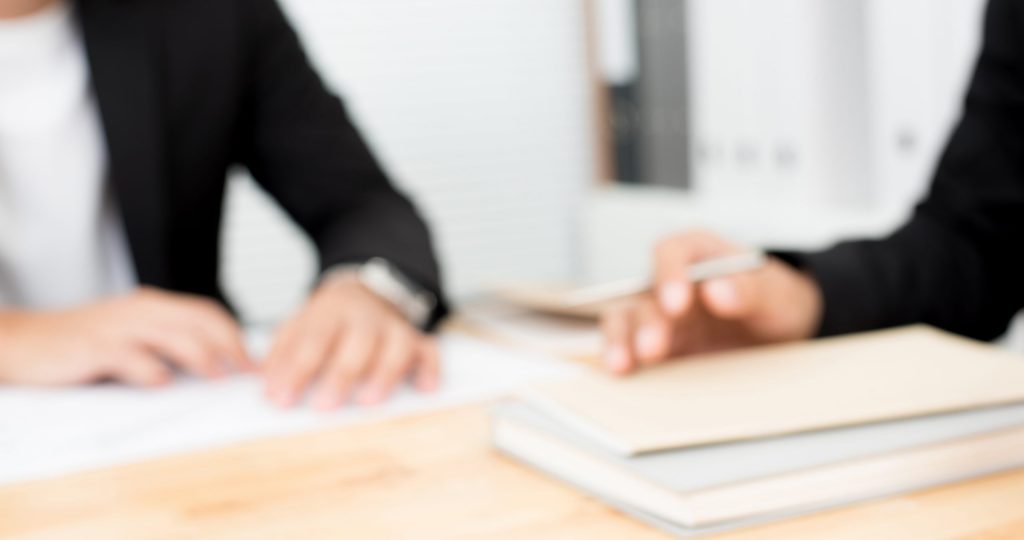 Blurred hands of businessmen on conference (meeting) table