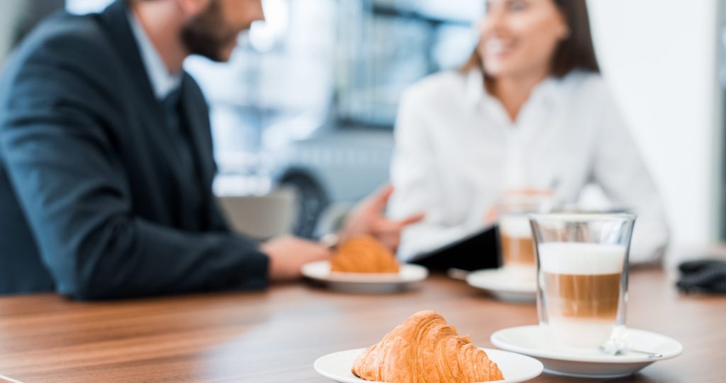 selective focus of tasty croissants near man and woman